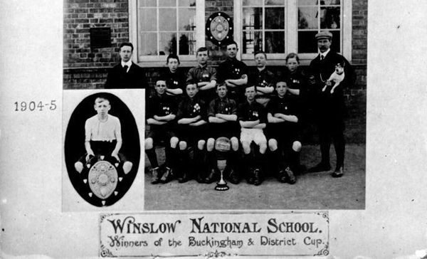 Football team with cup outside Winslow sschool