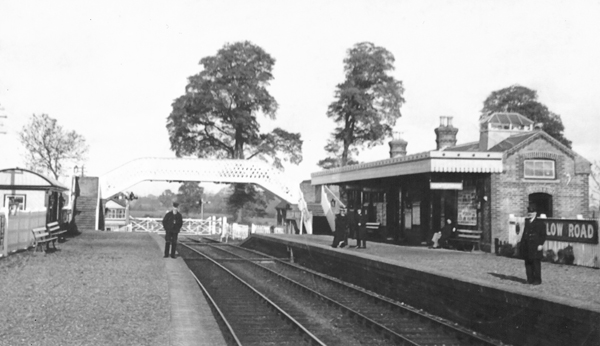 Photo of station looking north with footbridge and closed level crossing gate
